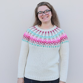 A model wearing a blue pink and white knit sweater
